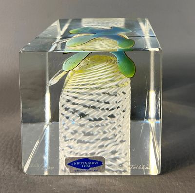 un vase en verre avec une fleur à l'intérieur sur une table
