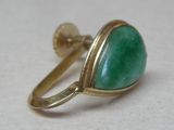gold ring with a green stone in it on a white surface