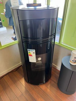 a black refrigerator in the corner of a room next to a table