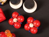 a close up of a pair of red and white flower earrings