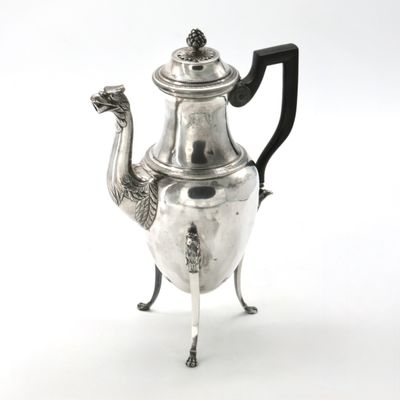 a silver tea pot with a bird on it