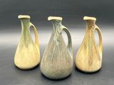 three vases sitting side by side on a table