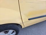a yellow car that has been damaged and is parked on the side of the road