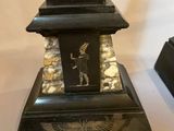pair of black and gold egyptian bookends with an eagle on top