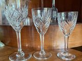 three wine glasses sitting on a wooden counter top