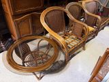 plusieurs chaises en osier et une table à plateau en verre dans une pièce