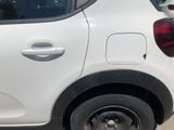 a small white car parked on the side of the road