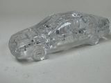a clear plastic model of a car on a white surface
