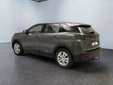 the back of a grey car in a room with a black floor