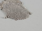 a close up of a chainmail purse on a white surface