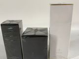 two boxes of perfume sitting next to each other on a white surface