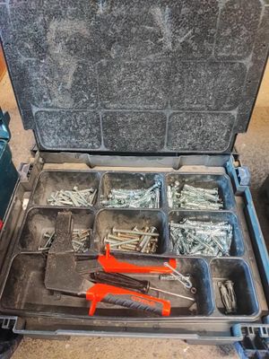 une boîte à outils contenant des outils, posée sur le sol