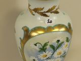 a white vase with a gold rim and flowers on it