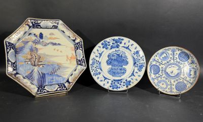 trois assiettes bleues et blanches sont posées sur une surface noire