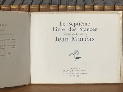 un livre ouvert posé sur une étagère à côté d'une pile de livres