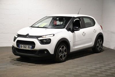 la citrole blanche est garee dans un garage au sol en damier