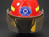 firefighter ' s helmet on display against a black background