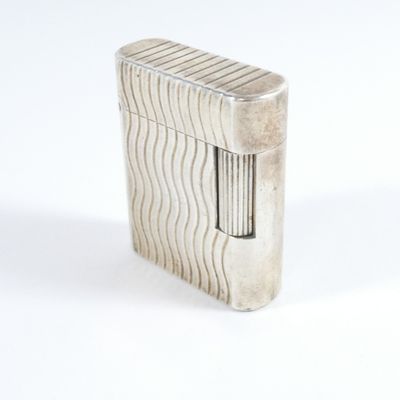 briquet argenté posé sur une surface blanche, avec un fond blanc