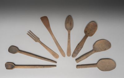 plusieurs cuillères et fourchettes en bois disposées en cercle sur une surface blanche