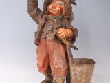 figurine of a man with a bucket and grapes in his hand