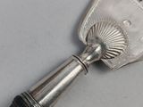 a silver spoon with a black handle on a table