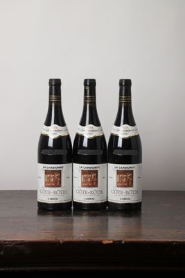 trois bouteilles de vin posées sur une table en bois