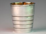 a close up of a silver cup on a white surface