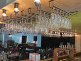 a bar with a bunch of wine glasses hanging from the ceiling