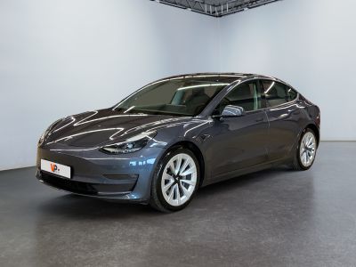 a dark tesla model 3 parked in a garage