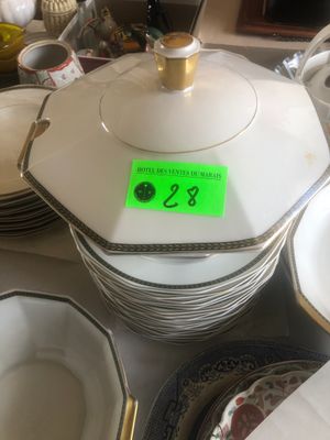 de nombreuses assiettes et bols posés sur la table, accompagnés d'une étiquette indiquant leur prix