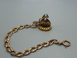 a close up of a gold chain with a bird on it
