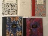 Quatre livres sont alignés sur une table blanche