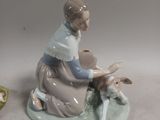a figurine of a woman sitting on a plate with a dog