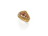 a close up of a gold ring with a red stone