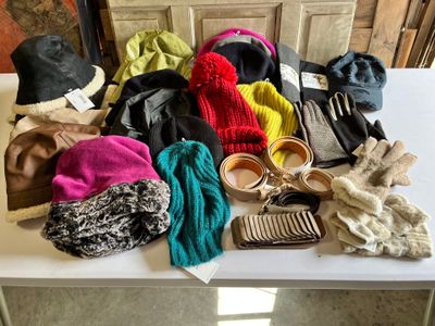 many hats and scarves on a table next to a pair of shoes