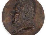 un gros plan sur un médaillon en bronze représentant le visage d'un homme