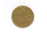 une vieille pièce d'or sur laquelle figure un blason