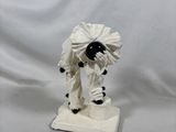 une figurine représentant un homme en costume blanc