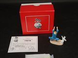une petite figurine représentant un homme sur un skateboard devant une boîte rouge
