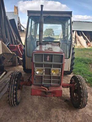 un tracteur garé sur un terrain en terre battue