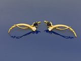 paire de boucles d'oreilles dorées ornées de pierres noires et blanches sur fond bleu