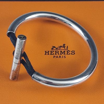un bracelet en argent muni d'un fermoir en métal sur une surface en cuir