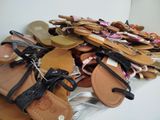 many pairs of sandals that are on a table