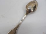 a silver spoon that is sitting on a white surface
