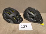 deux casques de vélo posés l'un à côté de l'autre sur une table