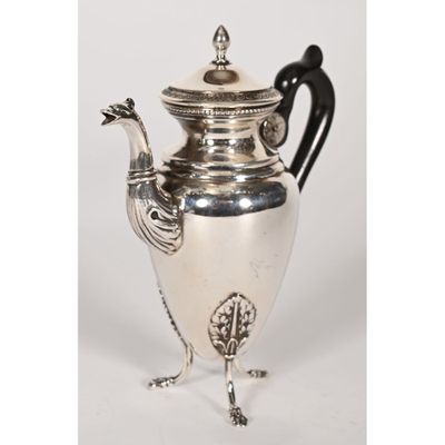 an antique silver plated teapot with a bird handle
