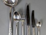 a lot of silverware on a table with a spoon and knife