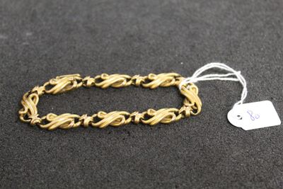 a close up of a gold bracelet with a tag on it