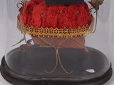 a red purse under a glass dome on a stand