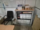 a desk with several files and a chair in front of it